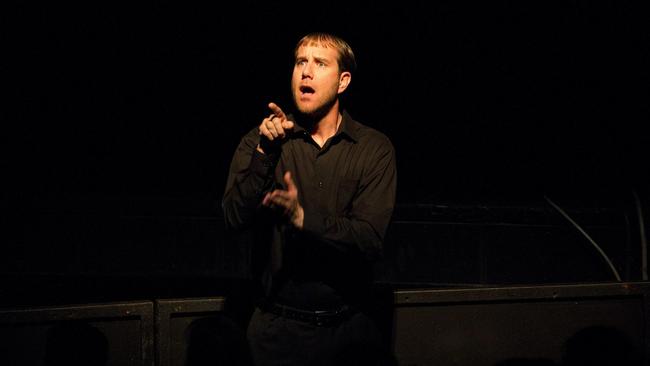 A sign language interpreter works in front of a stage.