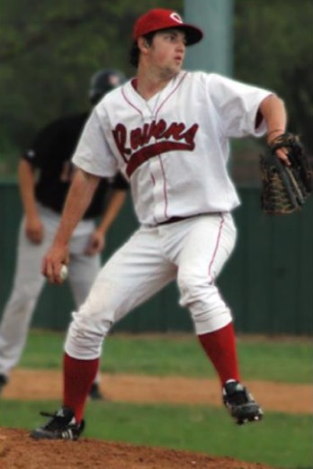 A teen boy in a baseball uniform throws a ball.