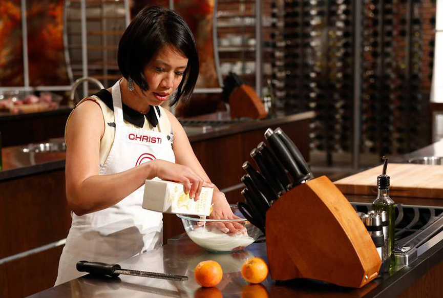 Christine Ha in a kitchen mixing ingredients.