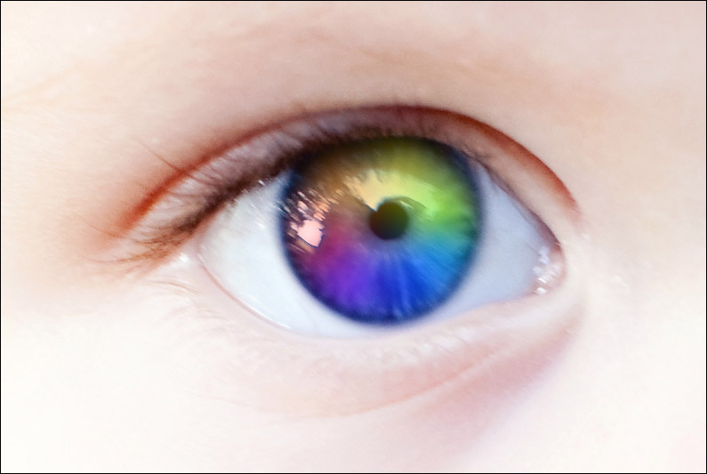 Close up a child's eye that is rainbow colored.