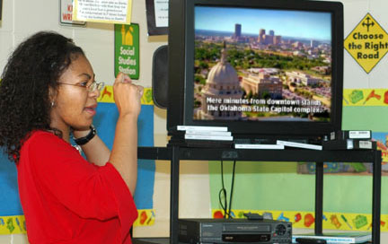 A woman uses sign language in a classroom.