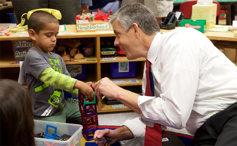 Former Secretary of Education Arne Duncan with a young student.