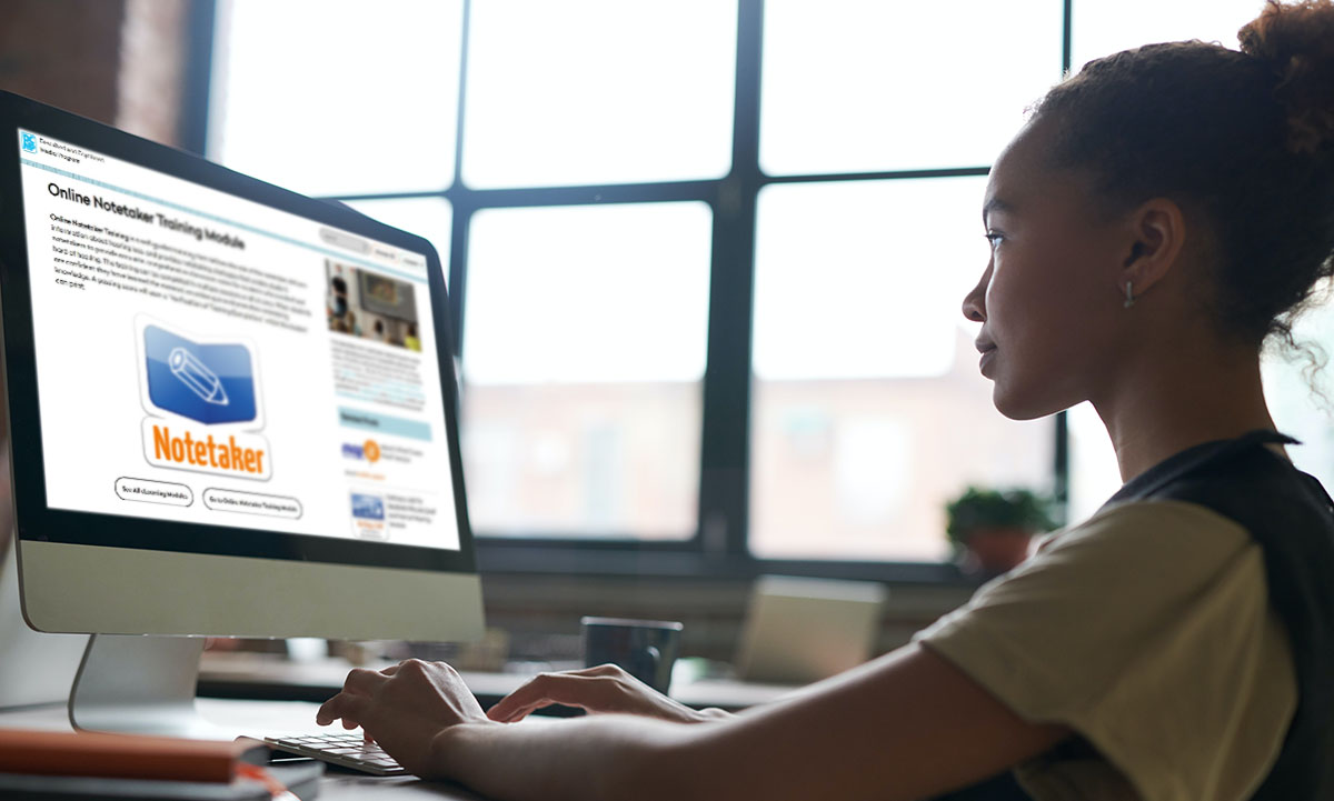 A young woman uses a desktop computer.