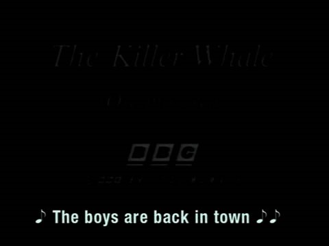Video still of dark screen. Caption says: (Musical note) The boys are back in town" (musical notes).