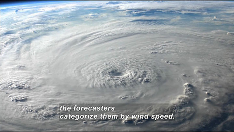 A large circular storm on Earth's surface, as seen from space. Caption: the forecasters categorize them by wind speed.