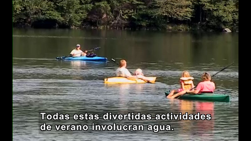 People in kayaks paddling on the water. Spanish captions.