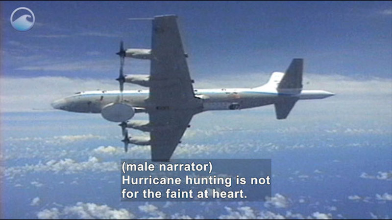 Aerial view of a large airplane in flight. Sensors dot the outside of the plane. Caption: (male narrator) Hurricane hunting is not for the faint at heart.