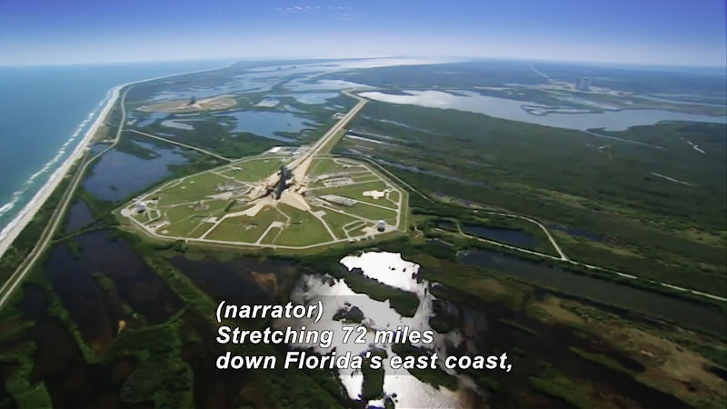 Complex of buildings and roads. Caption: (narrator) Stretching 72 miles down Florida's east coast,