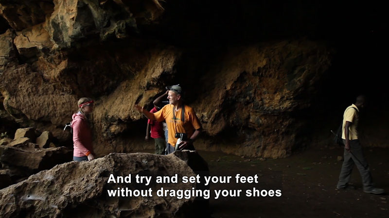 People walking through a cave. Caption: And try and set your feet without dragging your shoes