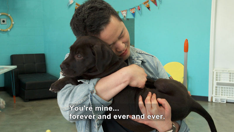 A person hugging a puppy. Caption: You're mine… forever and ever and ever.