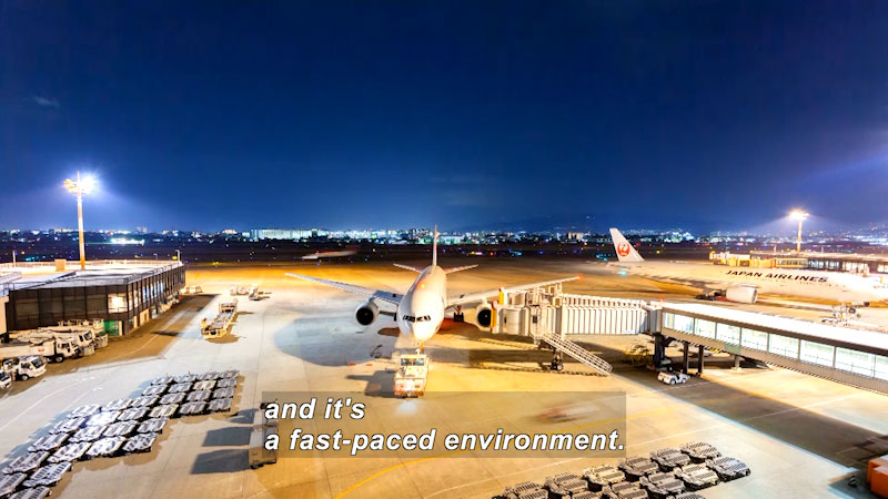 Airplanes on the tarmac with activity around them. Caption: and it's a fast-paced environment.