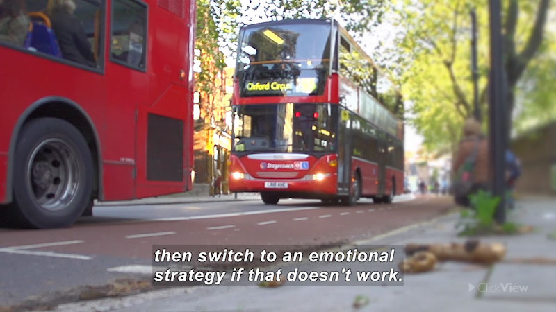 Two double-decker buses driving on a city street. Caption: then switch to an emotional strategy if that doesn't work.