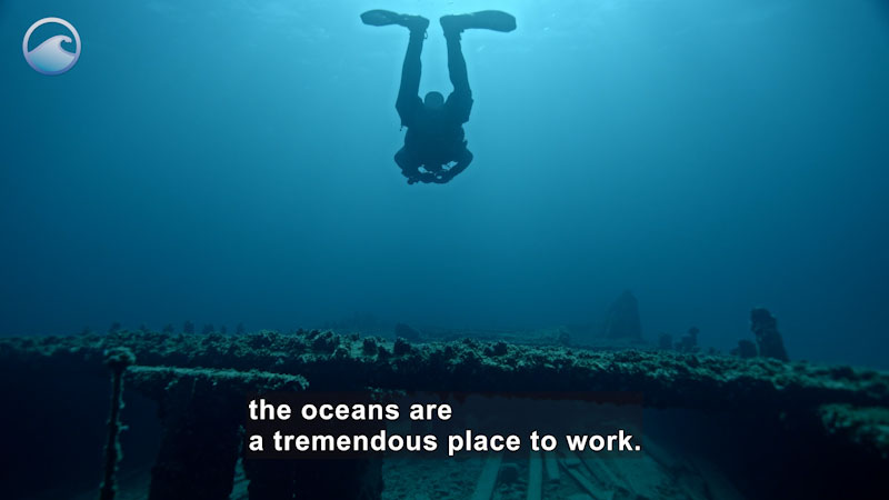 Scuba diver swimming above a flat surface covered in ocean detritus. Caption: the oceans are a tremendous place to work.