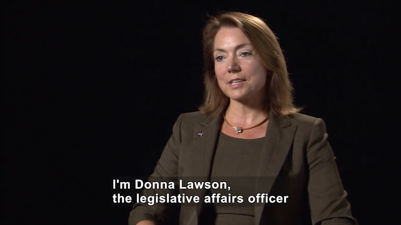 Woman speaking. Caption: I'm Donna Lawson, the legislative affairs officer