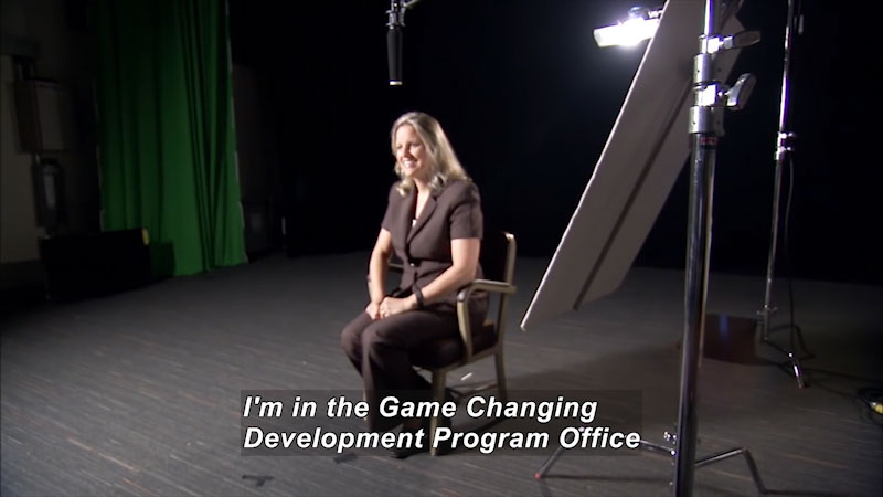 Woman speaking. Caption: I'm in the Game Changing Development Program Office