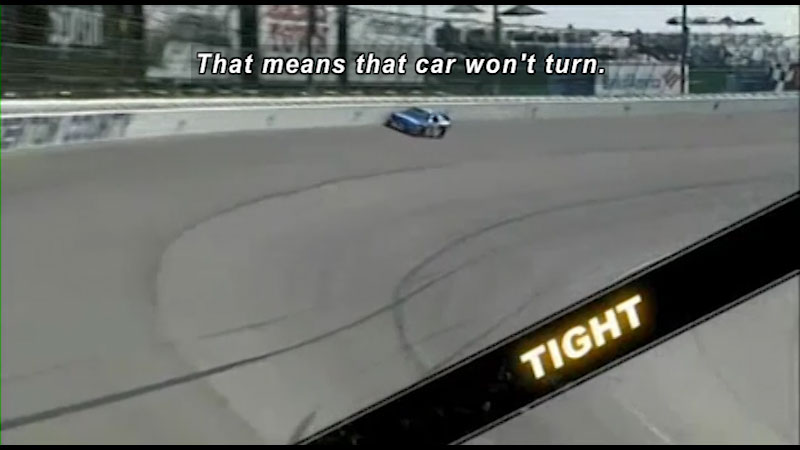 A race car about to go into a turn. Caption: That means that car won't turn. 