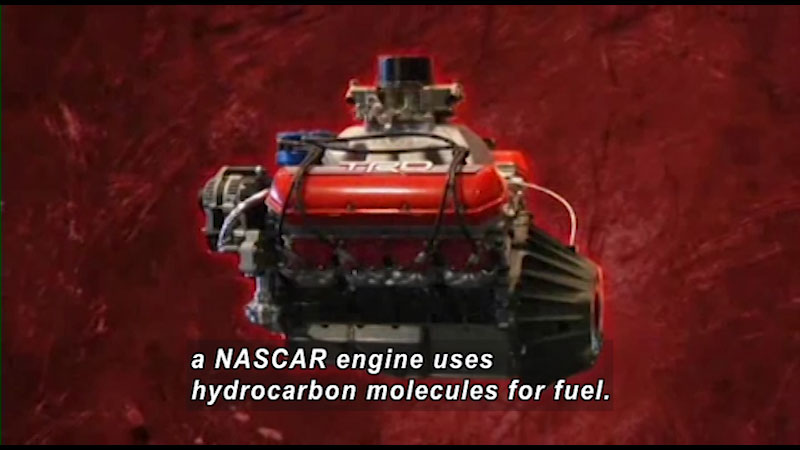 Side view of an engine. Caption: a NASCAR engine uses hydrocarbon molecules for fuel. 