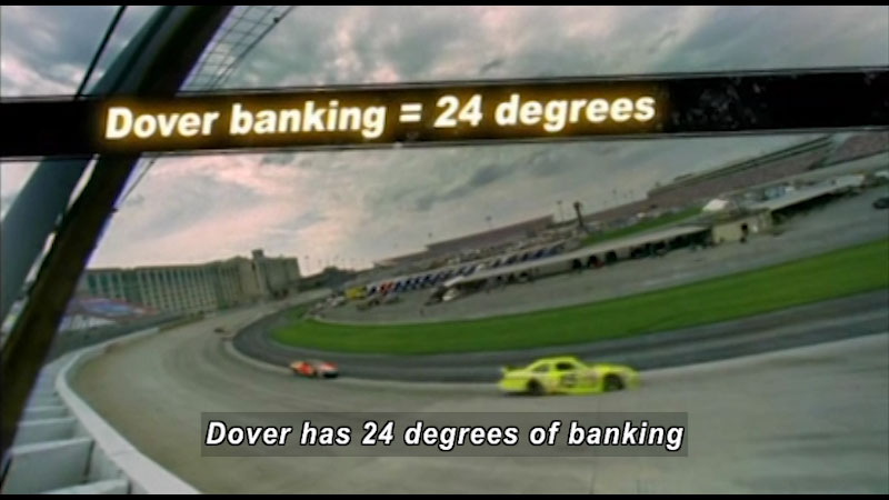 Two race cars barreling around a corner. Caption: Dover has 24 degrees of banking