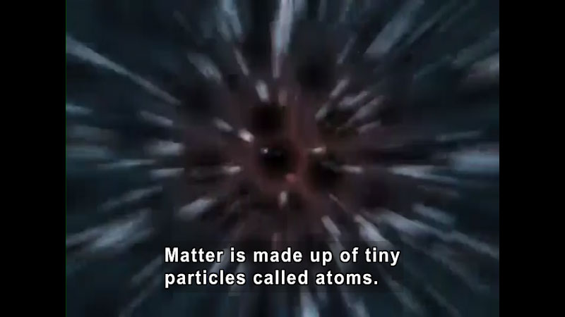 Points of light streaking toward a central point. Caption: Matter is made up of tiny particles called atoms.