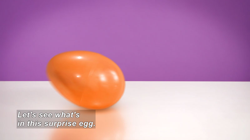 Orange plastic egg. Caption: Lets see what's in this surprise egg.