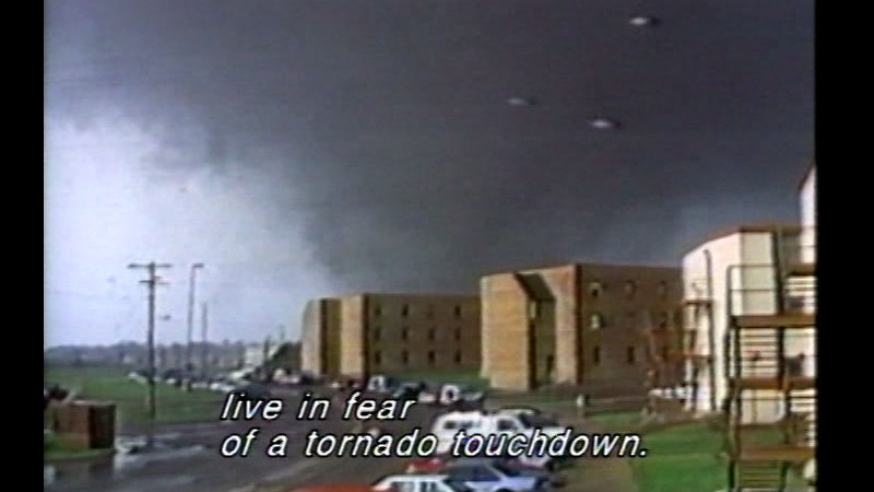 Tornado approaching several buildings. Caption: live in fear of a tornado touchdown. 