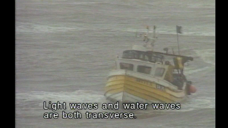 Photo: medium sized boat on a choppy lake with caption "Light waves and waves are both transverse".