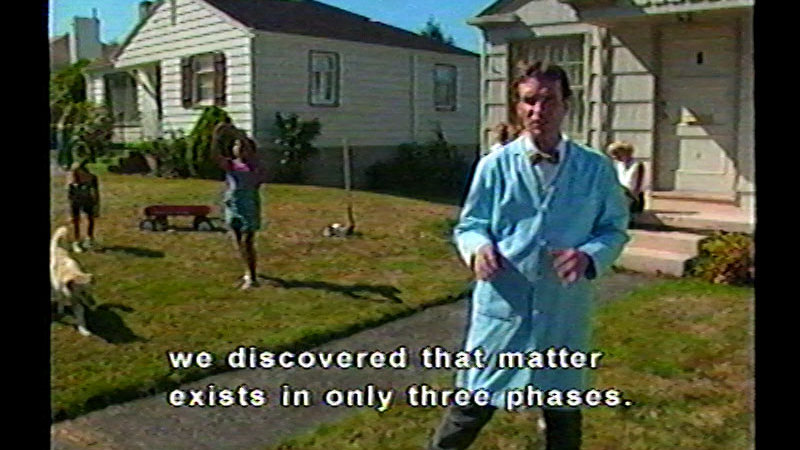 Person standing in front of houses with children playing in the background. Caption: we discovered that matter exists in three phases.