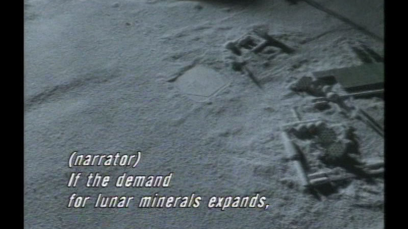 Aerial view of geometric objects on the surface of a planet. Caption: (narrator) If the demand for lunar minerals expands,