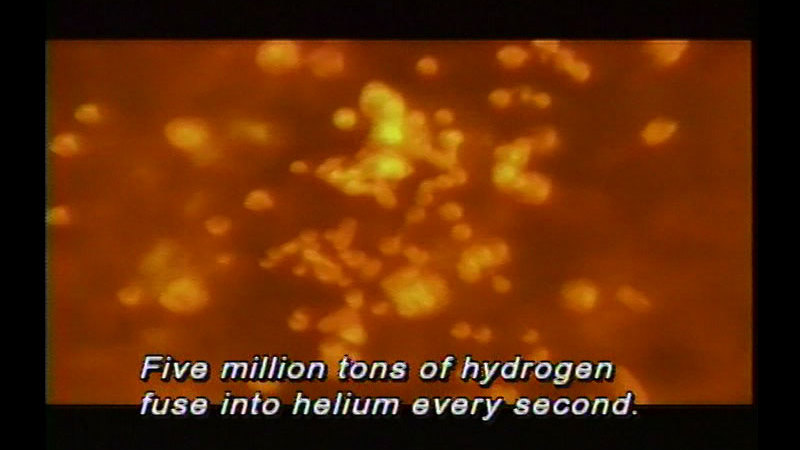 Blurry image of glowing orange dots. Caption: Five million tons of hydrogen fuse into helium every second. 