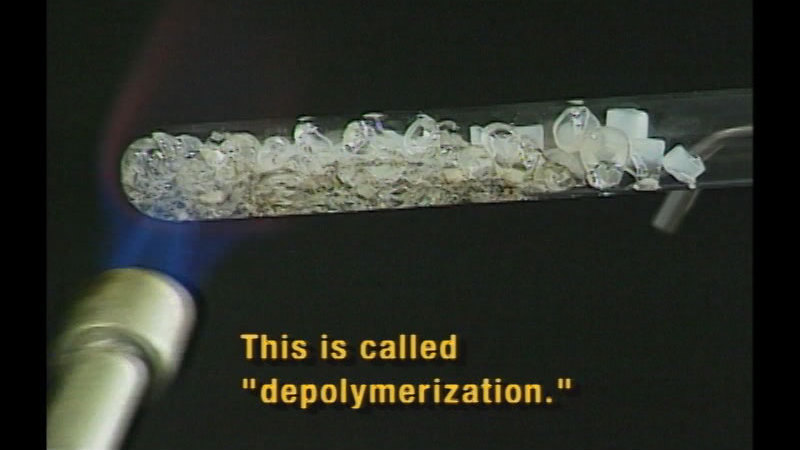 Clear pebble substance in a test tube melting as it is being heated by a flame. Caption: This is called "depolymerization."