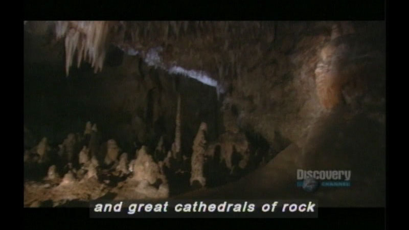 Cave with stalactites and stalagmites in light brown rock. Caption: and great cathedrals of rock