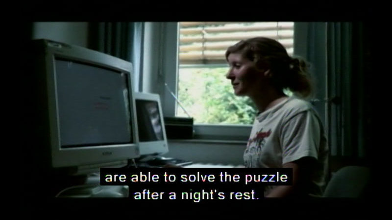 Person sitting in front of a computer screen. Caption: are able to solve the puzzle after a night's rest.