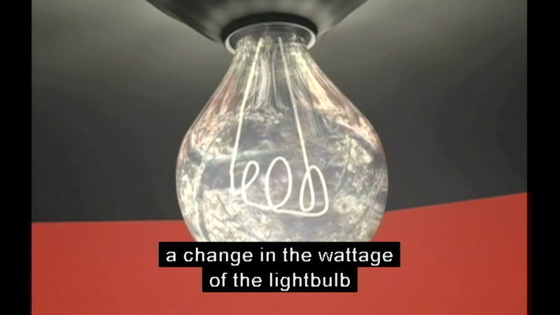 Closeup of an incandescent lightbulb. Caption: a change in the wattage of the lightbulb