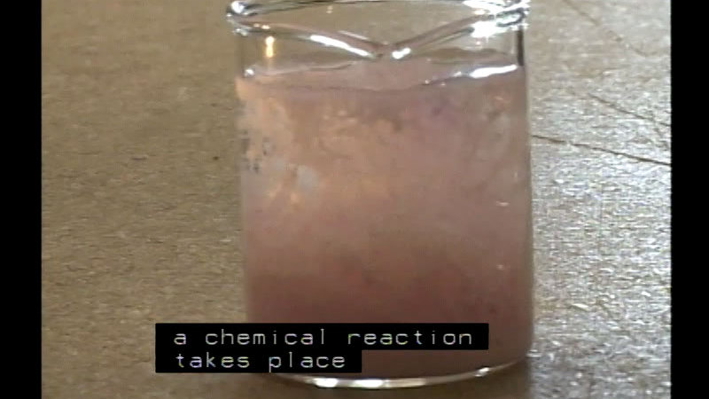 A beaker full of murky liquid. Caption: a chemical reaction takes place