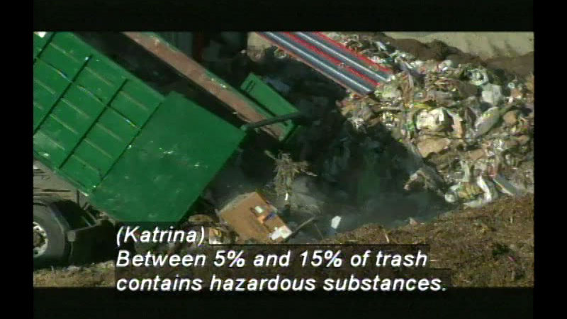 Garbage truck dumping a load of garbage in a landfill. Caption: (Katrina) Between 5% and 15% of trash contains hazardous substances.