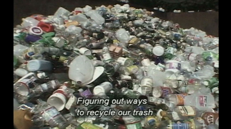 Empty glass and plastic bottles and cans. Caption: Figuring out ways to recycle our trash