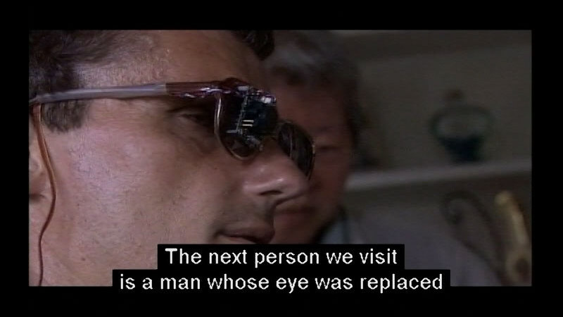 Person wearing dark glasses. Caption: The next person we visit is a man whose eye was replaced