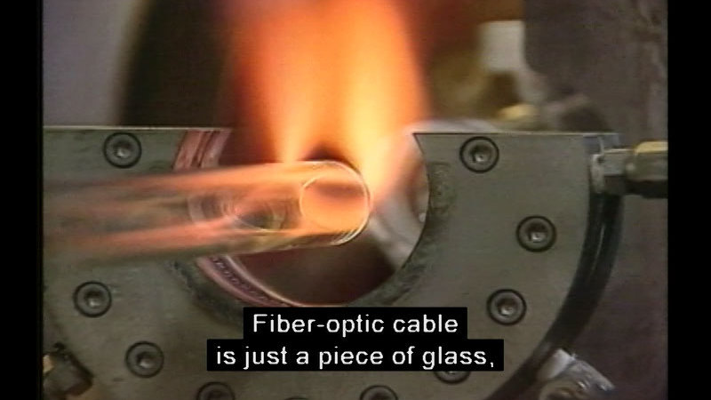 Hollow glass tub turning orange in a flame. Caption: Fiber-optic cable is just a piece of glass,