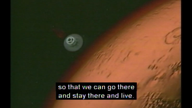 Small round space craft descending towards a red planet. Caption: so that we can go there and stay there to live.