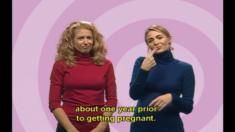 Two people standing and signing. Caption: about one year prior to getting pregnant.