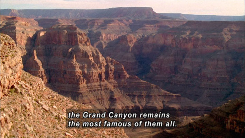 Steeply sloping walls of layered, red sedimentary rock. Caption: the Grand Canyon remains the most famous of them all.