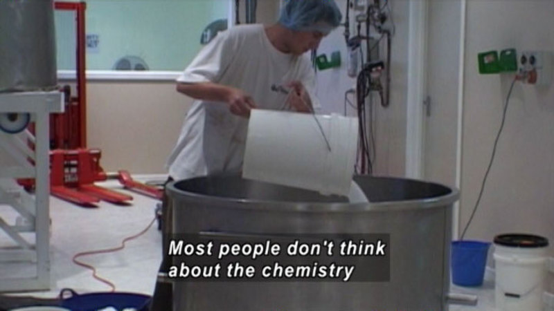 Person pouring fluid from a 5-gallon bucket into a large metal vat. Caption: Most people don't think about the chemistry