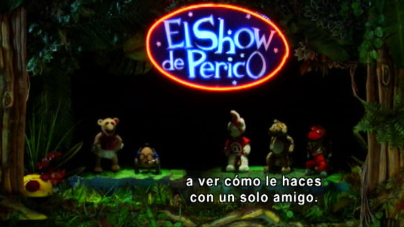 Five puppets on a stage. Spanish captions.