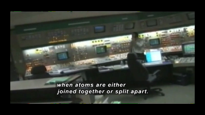 Person at a wall of controls. Caption: when atoms are either joined together or split apart.
