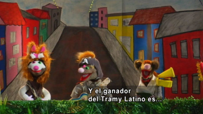 Three puppets walking down a road talking. Spanish captions.