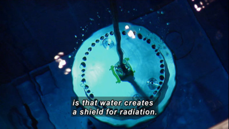 Round metal object underwater. Caption: is that water creates a shield for radiation.