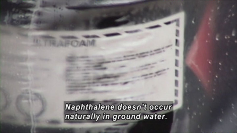 Blurry product label as seen through clear film. Caption: Naphthalene doesn't occur naturally in ground water.