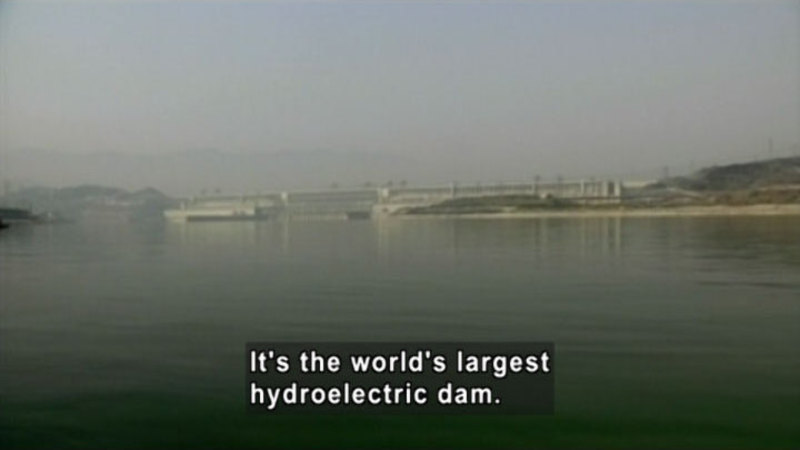 A large dam spanning across a lake. Caption: It's the world's largest hydroelectric dam. 