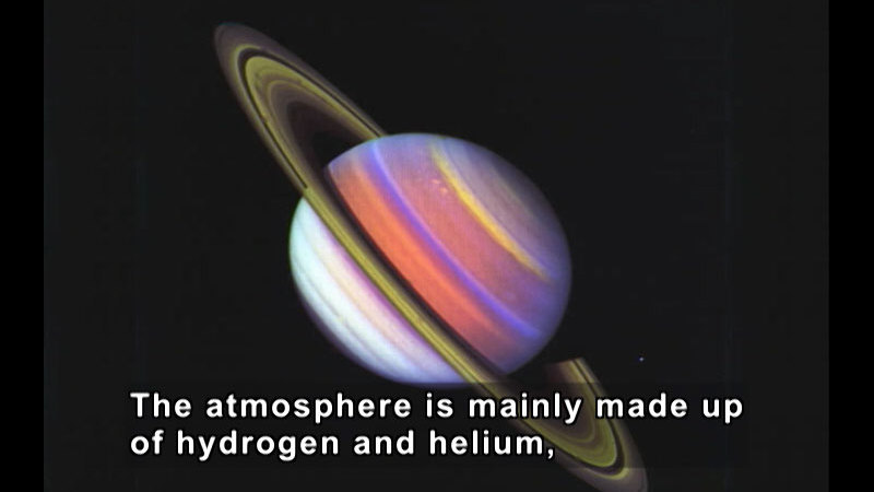 A planet with different colored bands on the surface and rings outside the atmosphere. Caption: The atmosphere is mainly made up of hydrogen and helium,