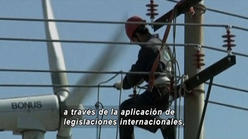Person working on powerlines.  Spanish captions.